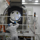 One of the largest camera's components getting inspected by a worker.